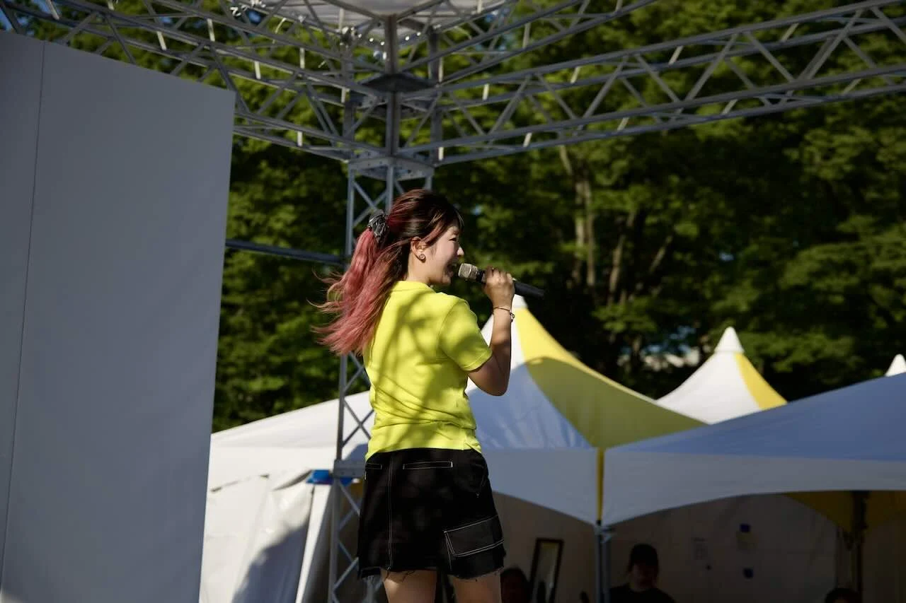 Yuuna singing toward the audience on the outdoor stage